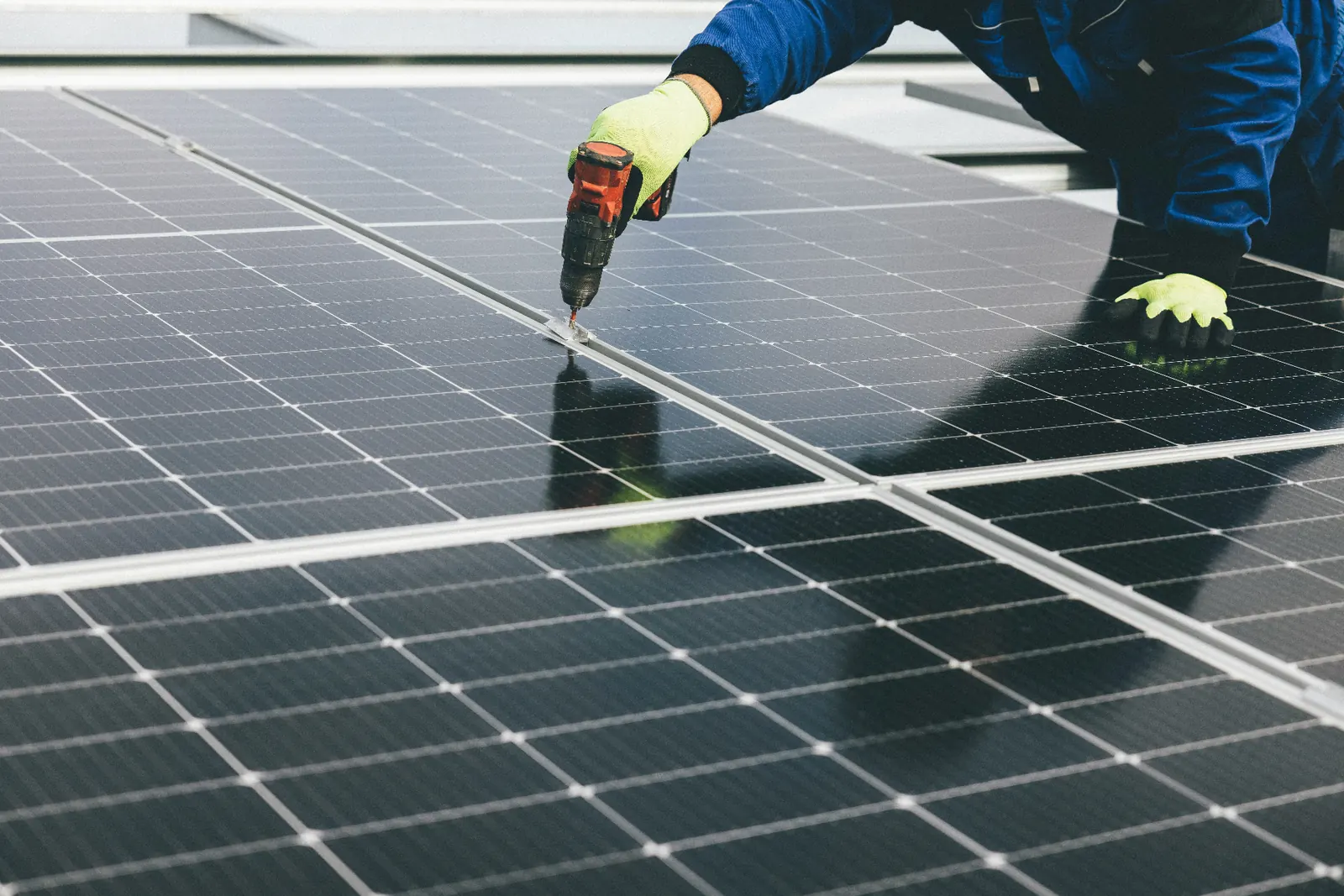 Licensed installer drilling rooftop solar panel mount in Ontario